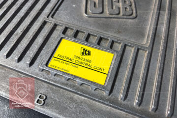 Záber na výrobný štítok riadiacej jednotky s jasne čitateľným modelovým číslom JCB 728/23300 a ďalšími špecifickými výrobnými údajmi.