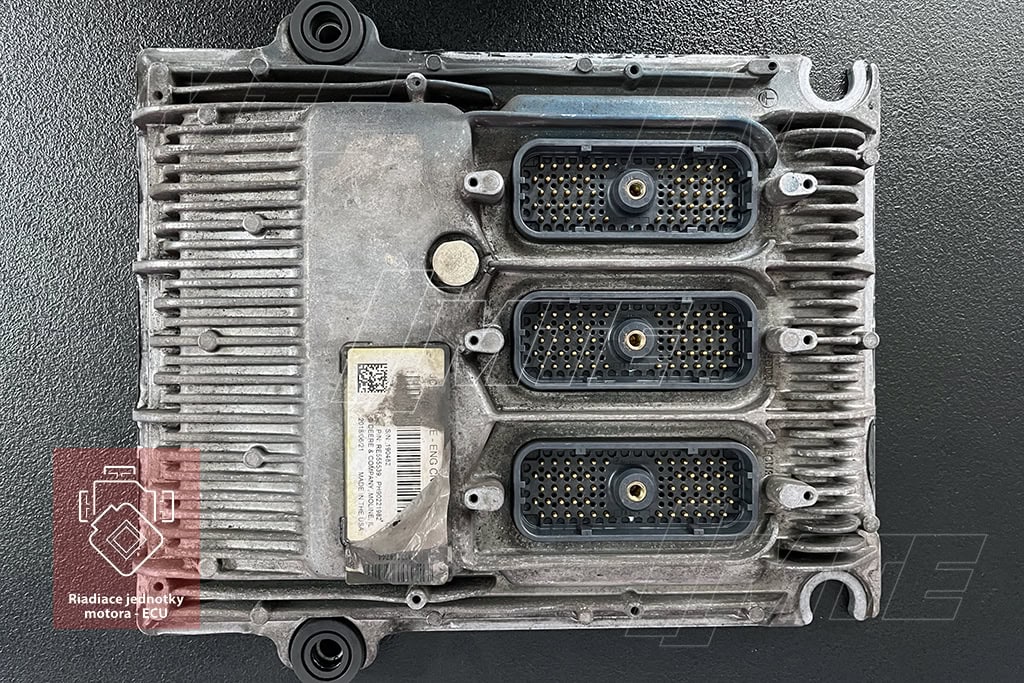 Celkový pohľad na doručenú riadiacu jednotku motora Phoenix L34 pred začatím servisného procesu. Zreteľné sú masívne konektory pre pripojenie k motorovému zväzku stroja a identifikačný štítok s číslom dielu RE555539, používaným v traktoroch aj priemyselných aplikáciách.